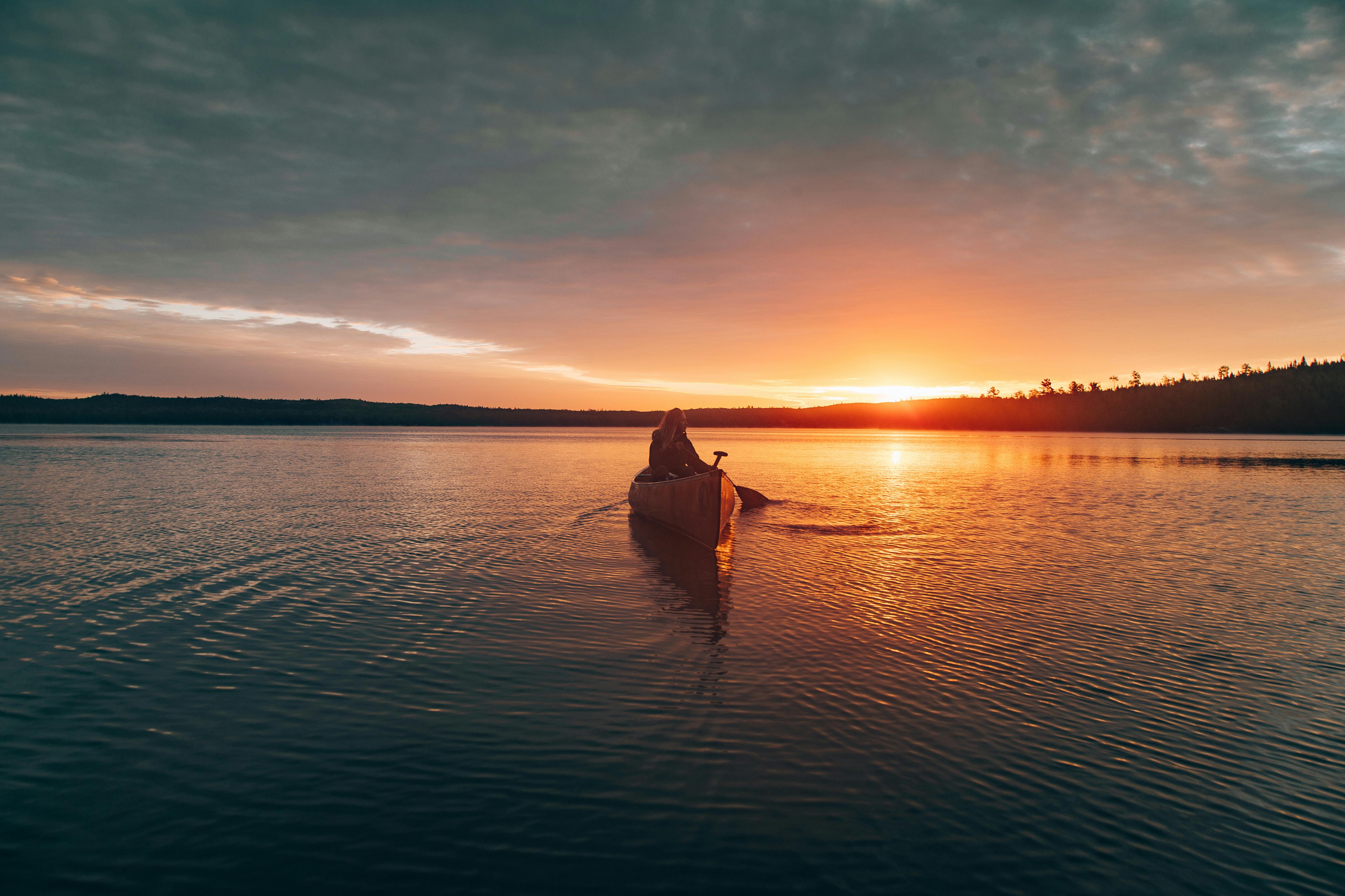 Paddle at dawn or dusk. women in canoe at sunset